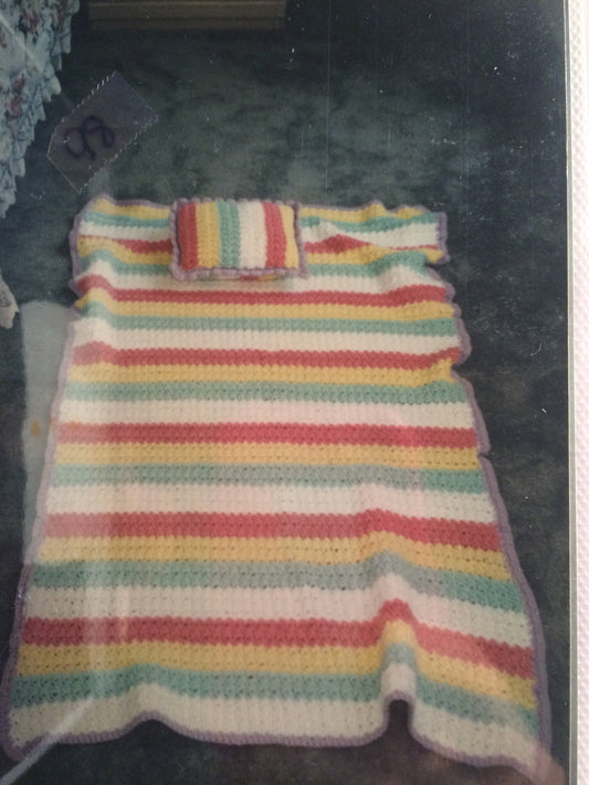 Gold yellow crocheted baby afghan with teal ruffle border - in baby crib